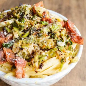 Linguine Carbonara with bacon and Crispy Brussels Sprouts in a white bowl