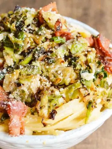 Linguine Carbonara with bacon and Crispy Brussels Sprouts in a white bowl