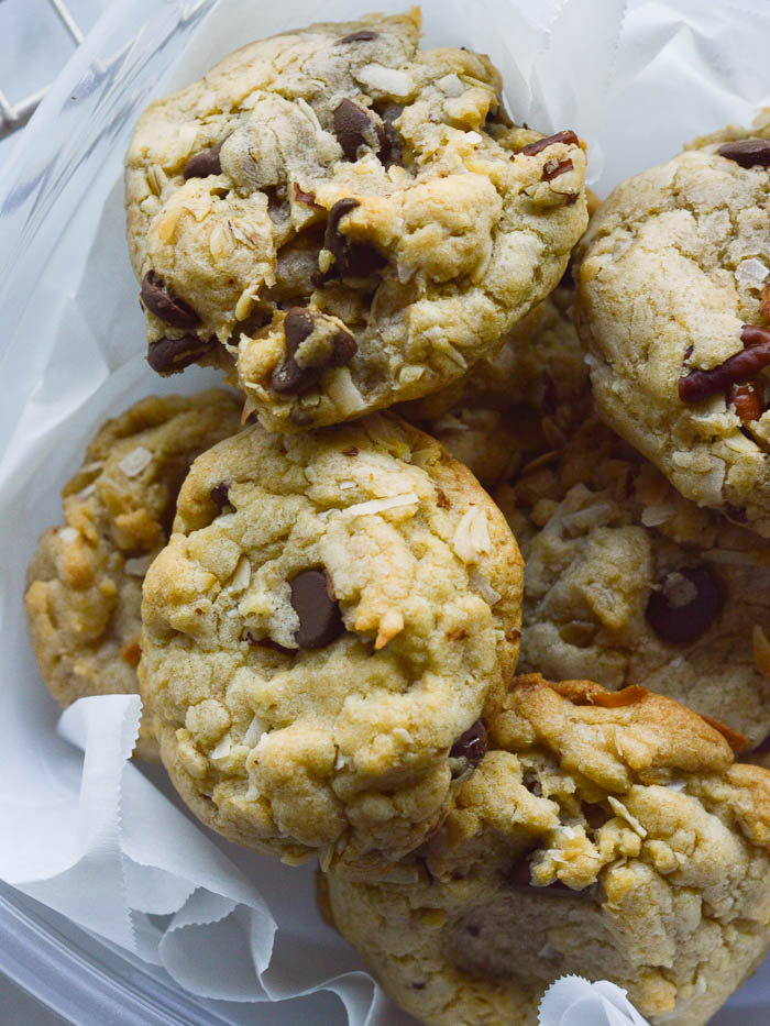 Carpool Cookies are thick, hearty cookies studded with chocolate chips and pecans. They are piled into a parchment-lined food storage container, perfect for taking with you in the car!