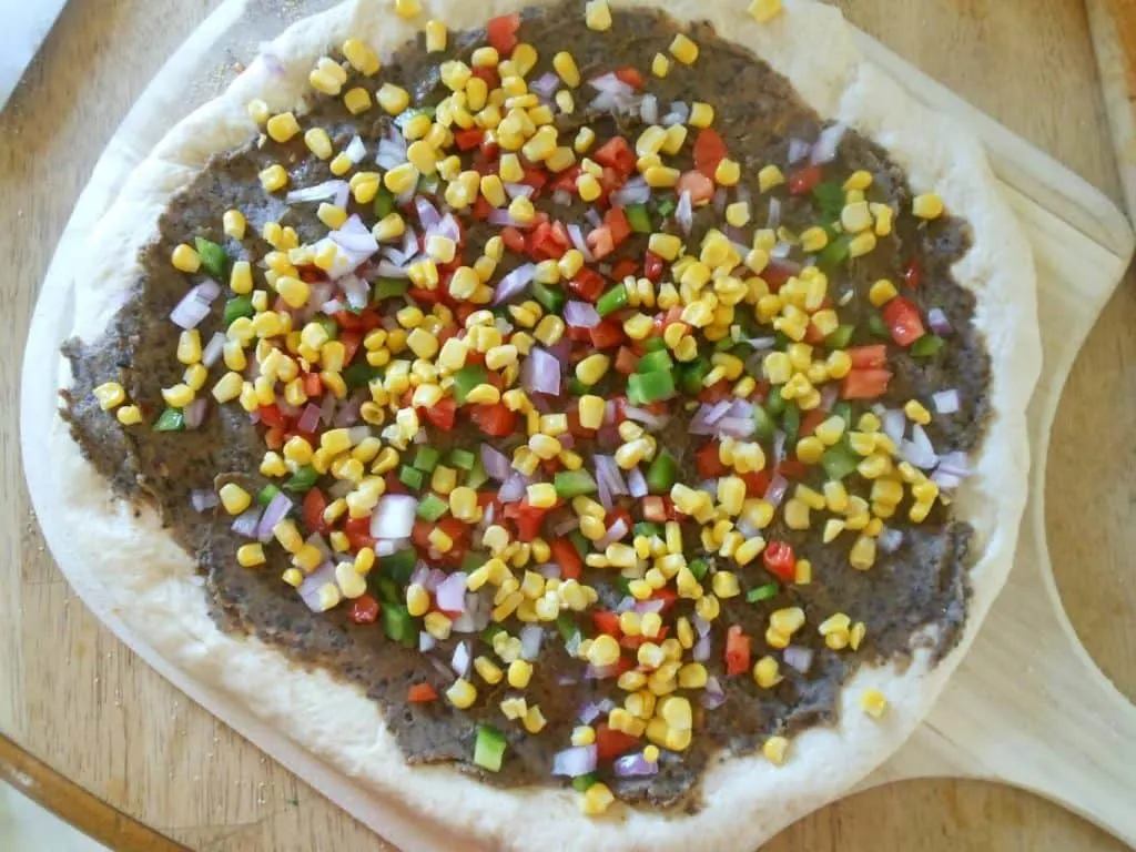 corn, peppers, and onions on pizza