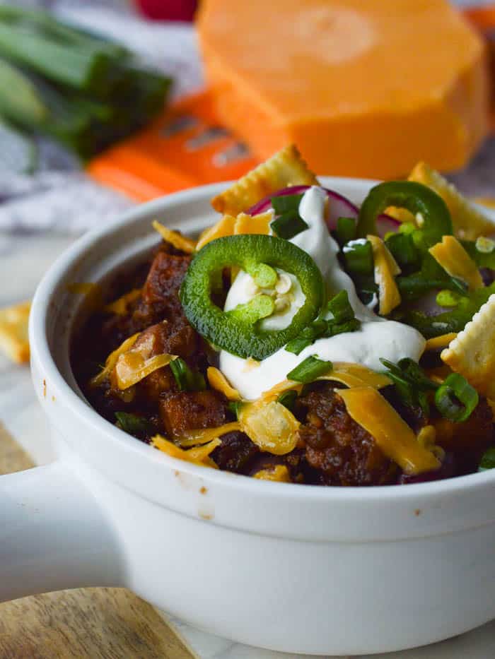Vegetarian Chili topped with cheddar cheese and sour cream and sliced jalapenos