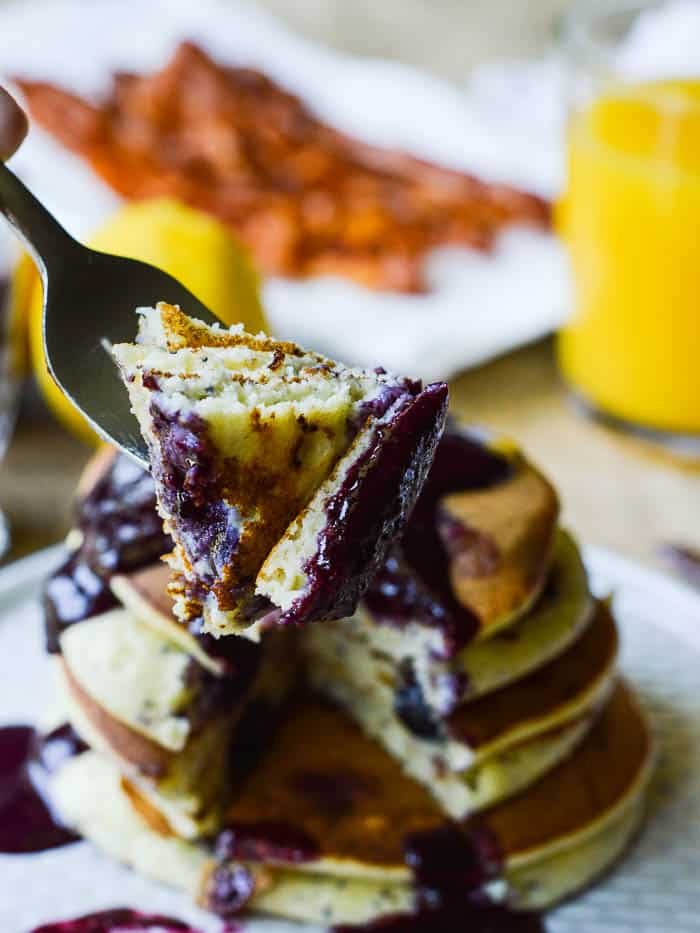 Bite of fluffy lemon poppy seed ricotta pancakes studded with fresh blueberries to show off the light texture of this ricotta pancake recipe. 