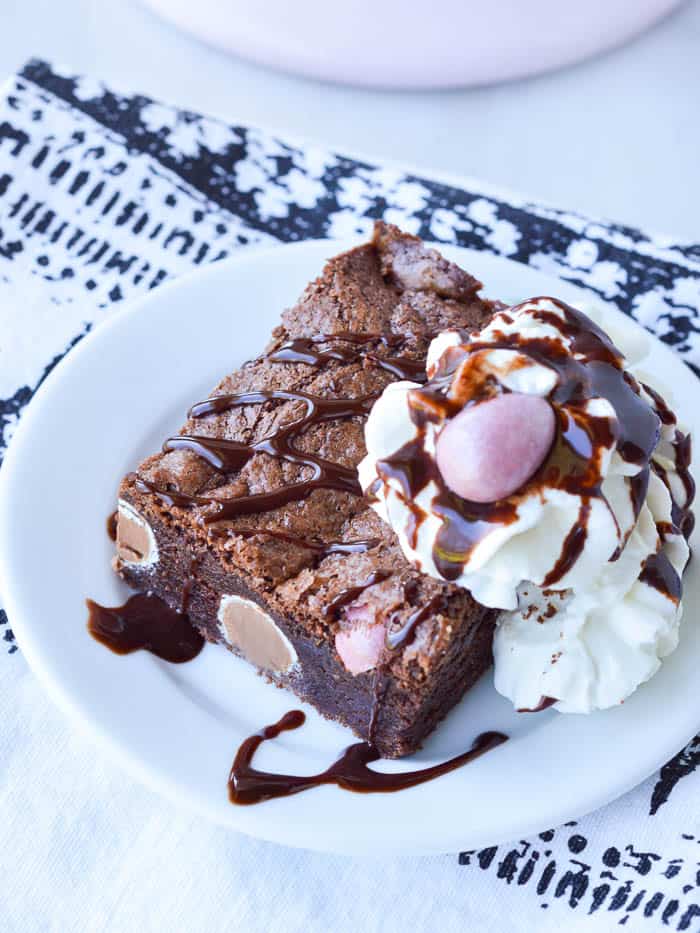 A Cadbury Candy Egg Brownie drizzled with chocolate and covered in whipped cream