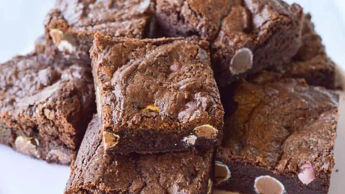 Cadbury Candy Egg Brownies piled high on a cake plate