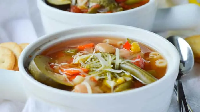 A close up look at this delicious summer vegetable soup loaded up with sliced zucchini, corn, green beans, cannellini beans, tomatoes, and more!