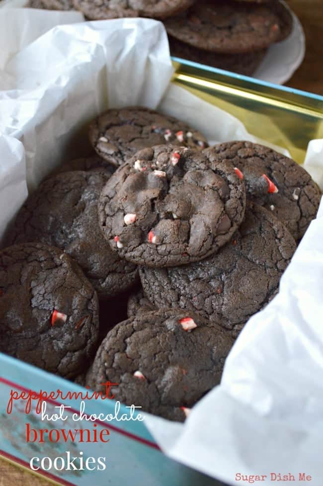 A tin lined with tissue paper and piled high with peppermint Hot Chocolate Brownie Cookies