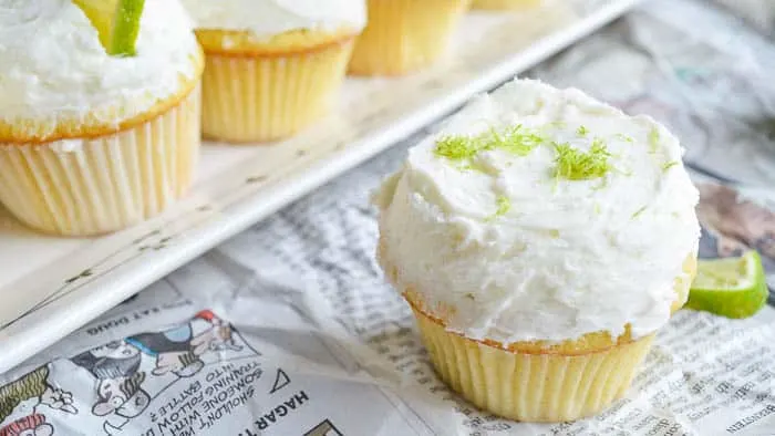 Tequila Cupcakes topped with Margarita Buttercream on a table covered in newsprint