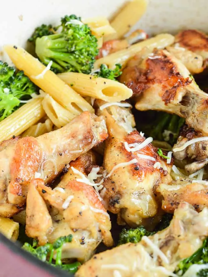 One Pot Garlic Chicken with penne and fresh broccoli in the pot, tossed with cheese, and ready to serve