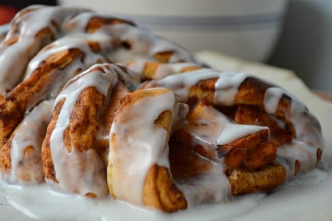 A baked apple cinnamon breakfast braid drenched in cinnamon roll icing. 