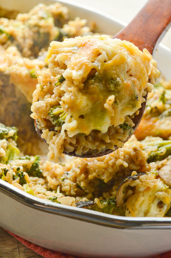 A wooden spoon heaped with brown rice, broccoli, and cheese from this Healthy Broccoli Rice Casserole Recipe