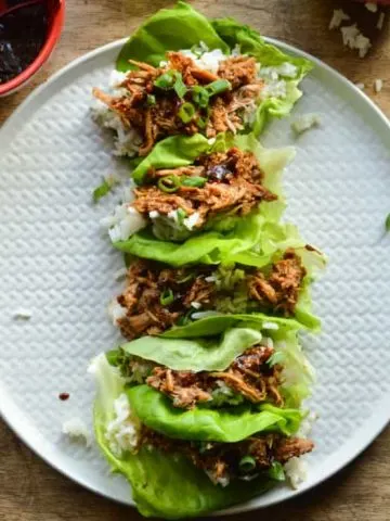 Chinese Pork lettuce Wraps overhead image; bright green Boston Bibb lettuce, tender Chinese BBQ pork, and a little sticky jasmine rice.