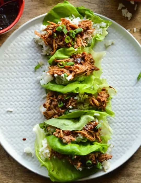 Chinese Pork lettuce Wraps overhead image; bright green Boston Bibb lettuce, tender Chinese BBQ pork, and a little sticky jasmine rice.