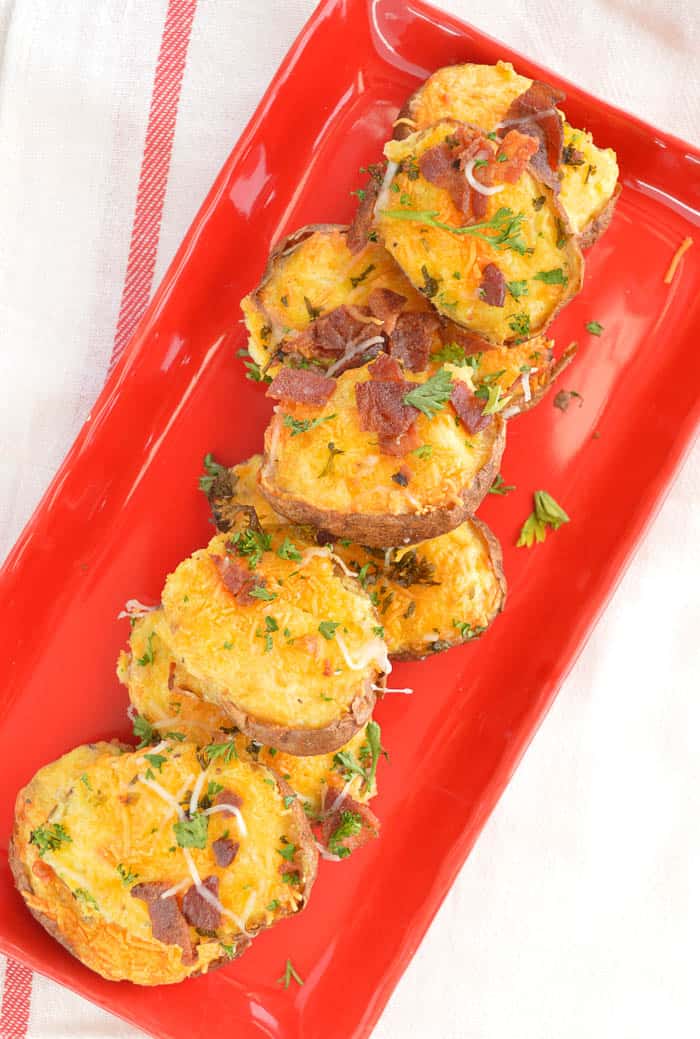 Twice Baked Breakfast Potatoes on a red plate viewed from overhead and ready to serve