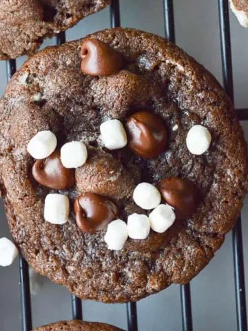 Hot Cocoa Cookies are chocolate with chocolate chips and are covered in little mallow bits