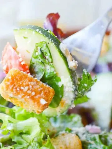 A forkful of my Favorite Italian salad. The dressing is a creamy Italianj made with white vinegar and plenty of cheese.