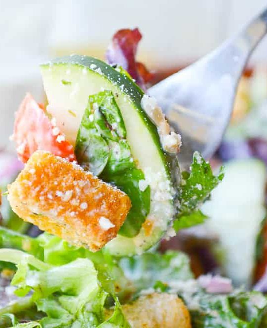 A forkful of my Favorite Italian salad. The dressing is a creamy Italianj made with white vinegar and plenty of cheese.