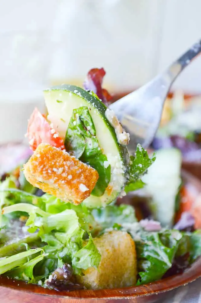 You won't want to miss this Italian salad recipe! A forkful of leafy greens, tomatoes, croutons, cucumbers, and carrot ribbons. 