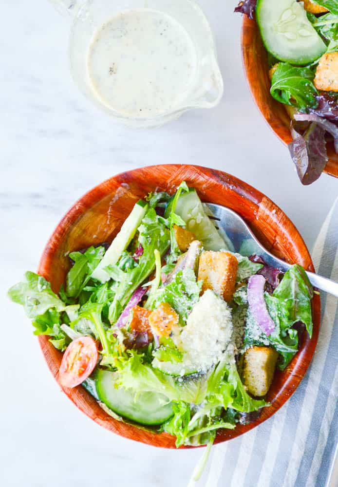 An overhead view of Italian salads in wooden bowls. The veggies are coated in my favorite Italian salad dressing