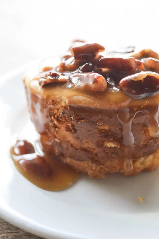 A close look at Spiced Rum Pecan Cheesecakes. They have a shortbread crust, a spiced rum smooth cheesecake filling, and are topped with a thick boozy caramel sauce loaded with pecans