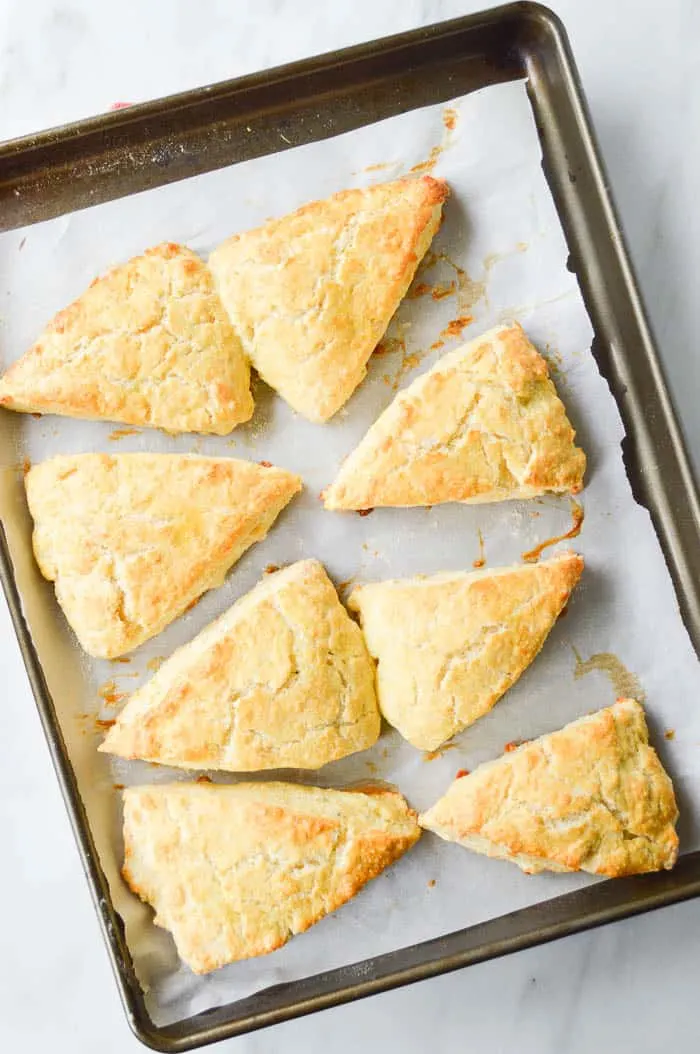 Fluffy Garlic Herb and Cheddar Scones on a parchment lined baking sheet, warm and ready to serve