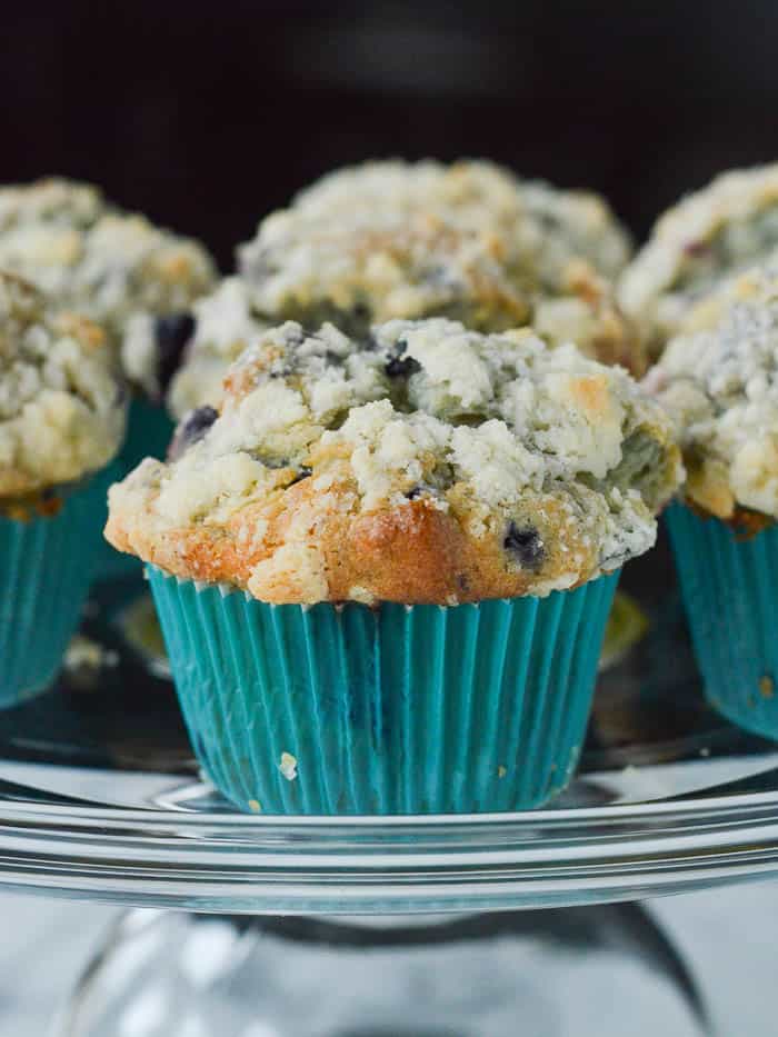 High-domed Blueberry Muffins with a gorgeous crumb topping in teal paper wrappers