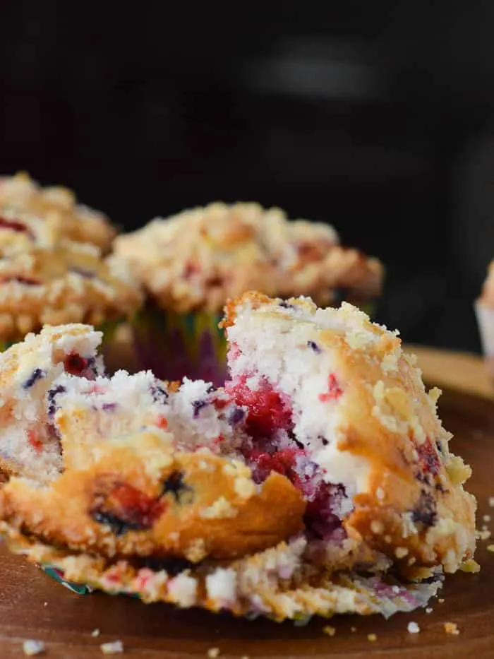 Mixed Berry Muffins warm and split open on a plate, ready to eat!
