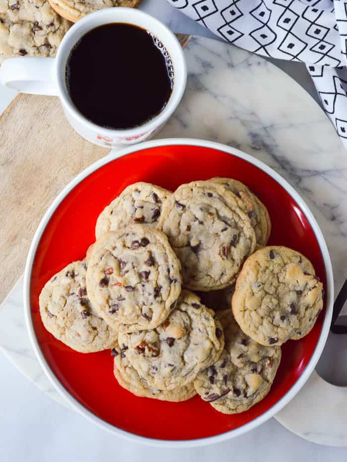 overhead view of Chocolate Chip Blondie Cookies on a red plate with a ciup of coffee to the side