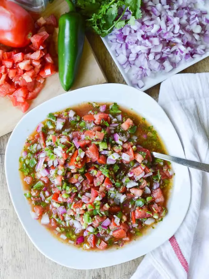 Overhead view of pico de gallo and all the ingredients needed to make it