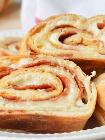 Slices of Easy Stromboli in a white dish with a red and white flour sack towel ready for serving