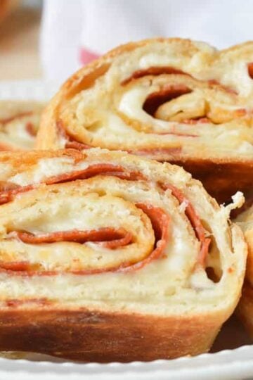 Slices of Easy Stromboli in a white dish with a red and white flour sack towel ready for serving