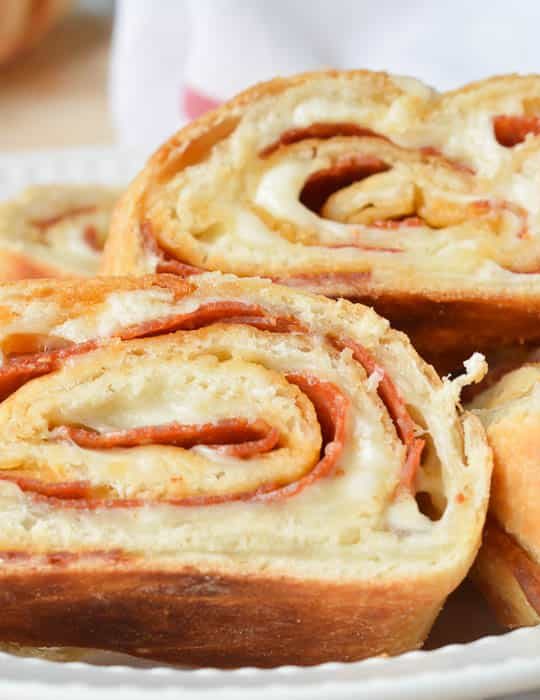 Slices of Easy Stromboli in a white dish with a red and white flour sack towel ready for serving