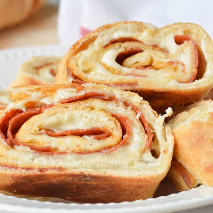 Slices of Easy Stromboli in a white dish with a red and white flour sack towel ready for serving