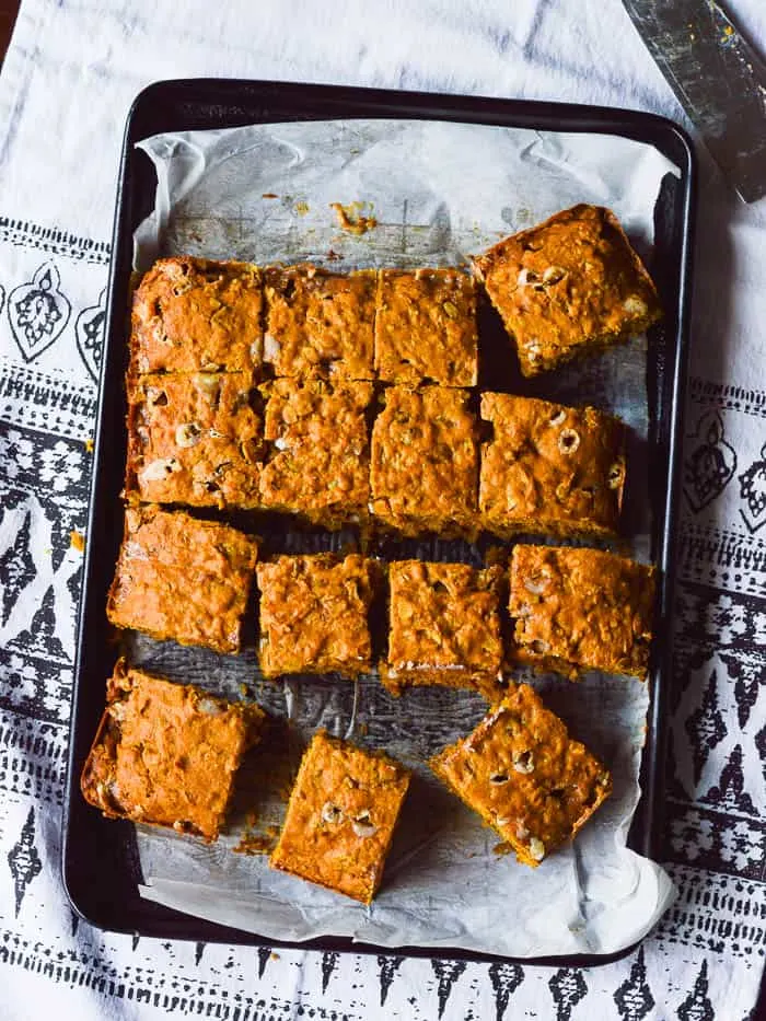 Overhead view of easy pumpkin cake sliced like blondie bars and ready to be plated