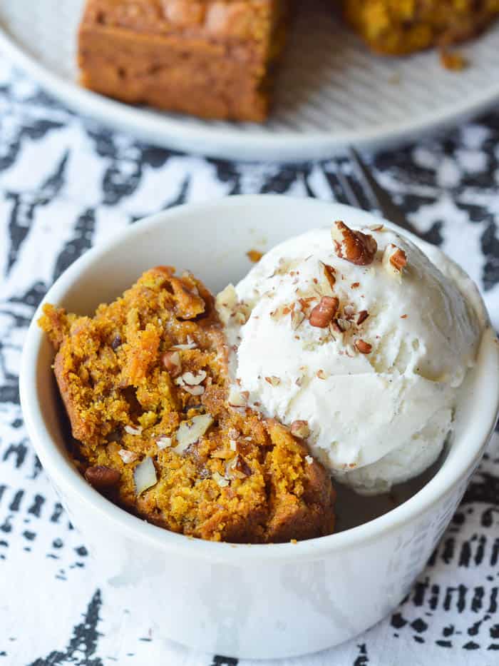 This fabulous fall dessert is made with warm Pumpkin Cake Bars and a scoop of vanilla bean ice cream, sprinkled with toasted chopped pecans