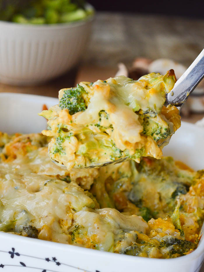 A serving spoon heaped with classic broccoli and rice casserole, made with fresh broccoli, Cheez Whiz, Minute Rice, and cream of mushroom soup. 