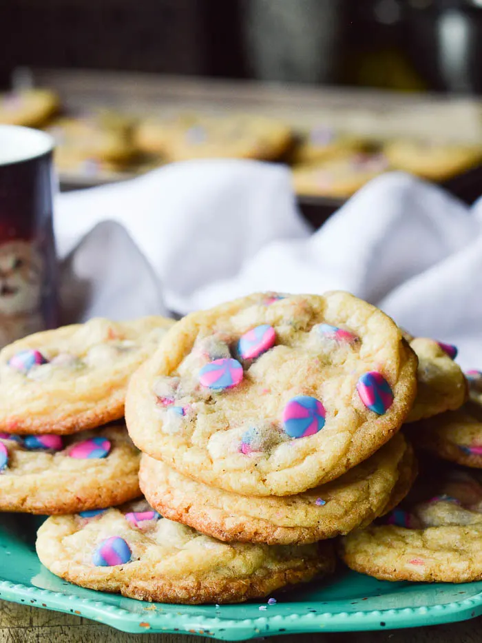 A stack of Unicorn Cake Mix Cookies, which are soft and chewy vanilla and brown sugar cookies, made with white cake mix, studded with bright pink and blue unicorn chips.