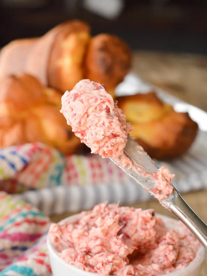 A dollop of whipped and creamy strawberry butter on the end of a small butter knife ready for spreading. 