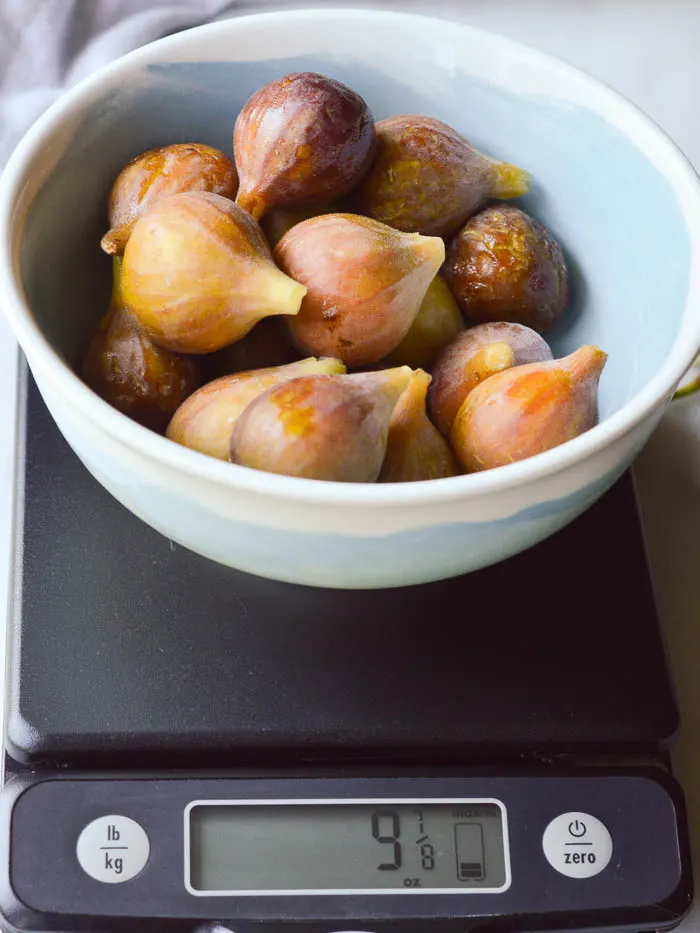 16 common fresh figs in a bowl on a food scale, weighing in at 9 7/8 ounces