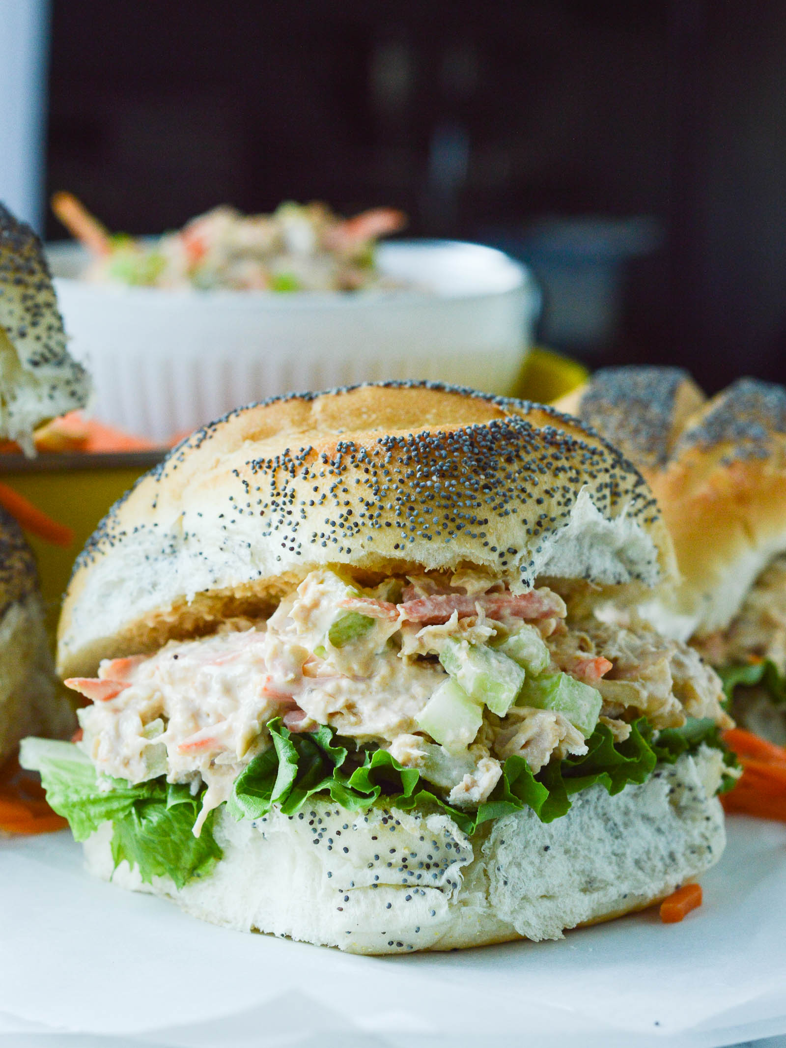 Buffalo Chicken Salad piled onto a fluffy poppy seed bun with green leafy lettuce