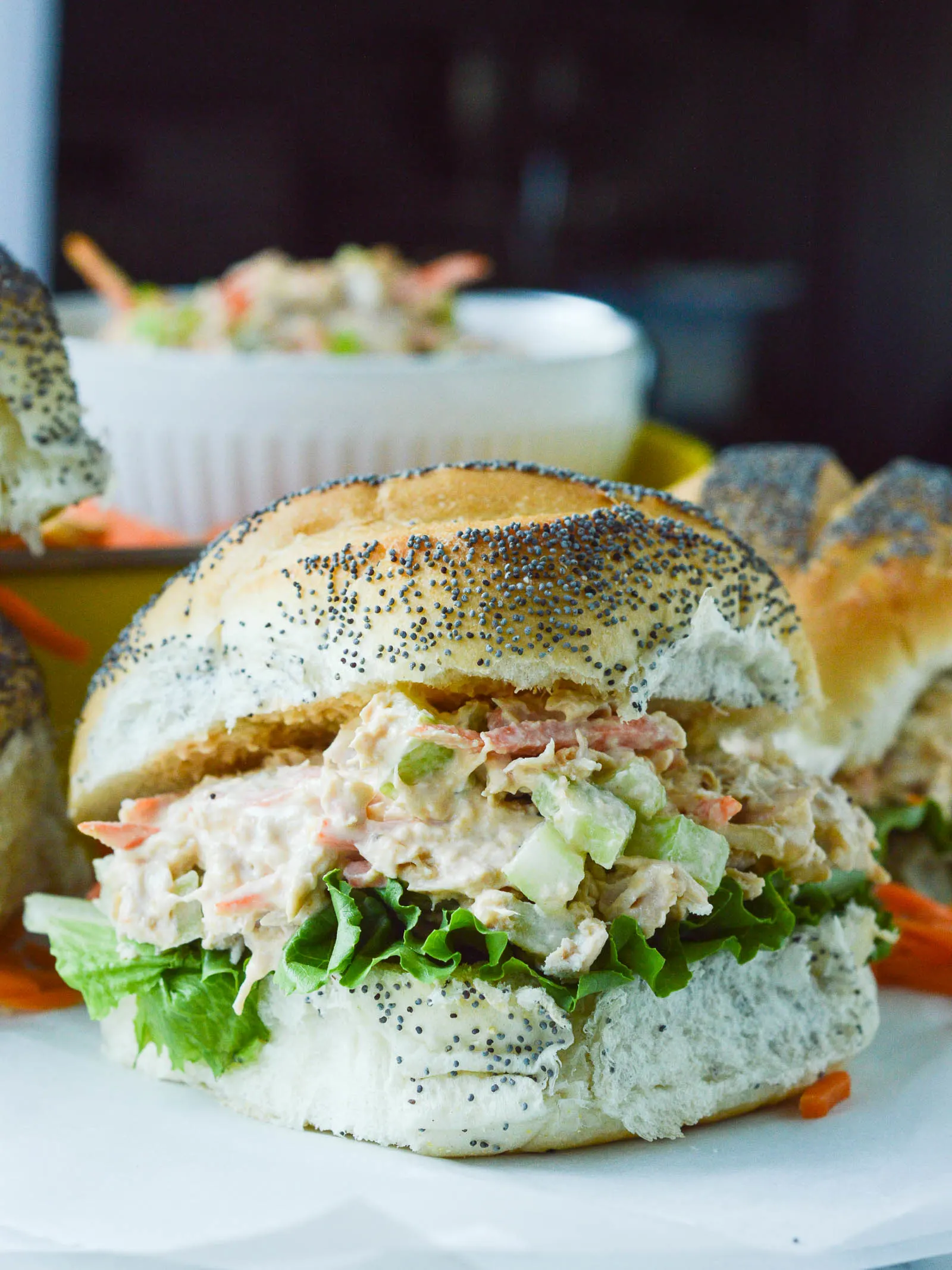 Buffalo Chicken Salad piled onto a fluffy poppy seed bun with green leafy lettuce