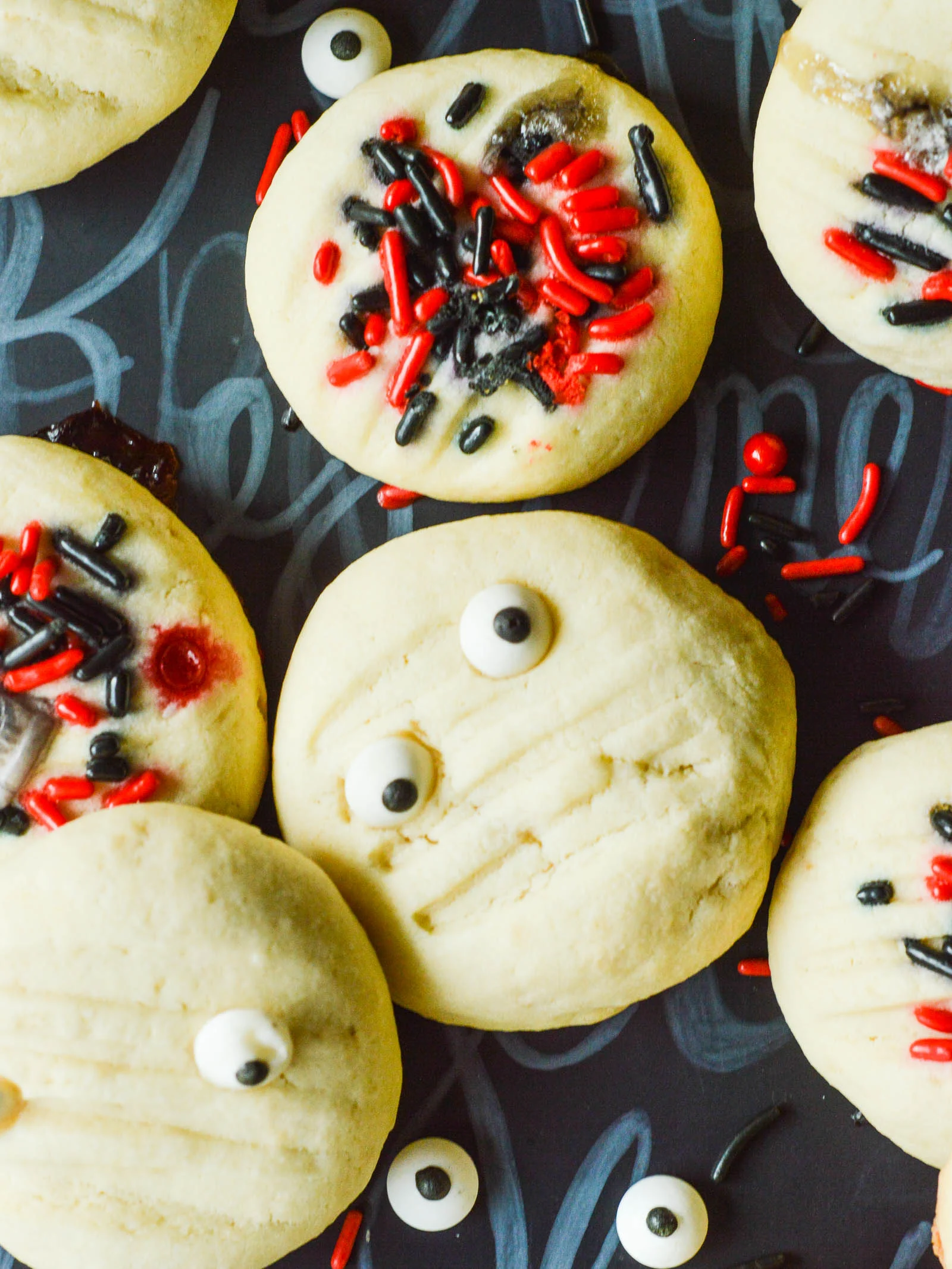An overhead view of round Whipped Shortbread Cookies with sprinkles and candy eyes. They are smooth and buttery, and a little bit fluffier than a traditional shortbread cookie.